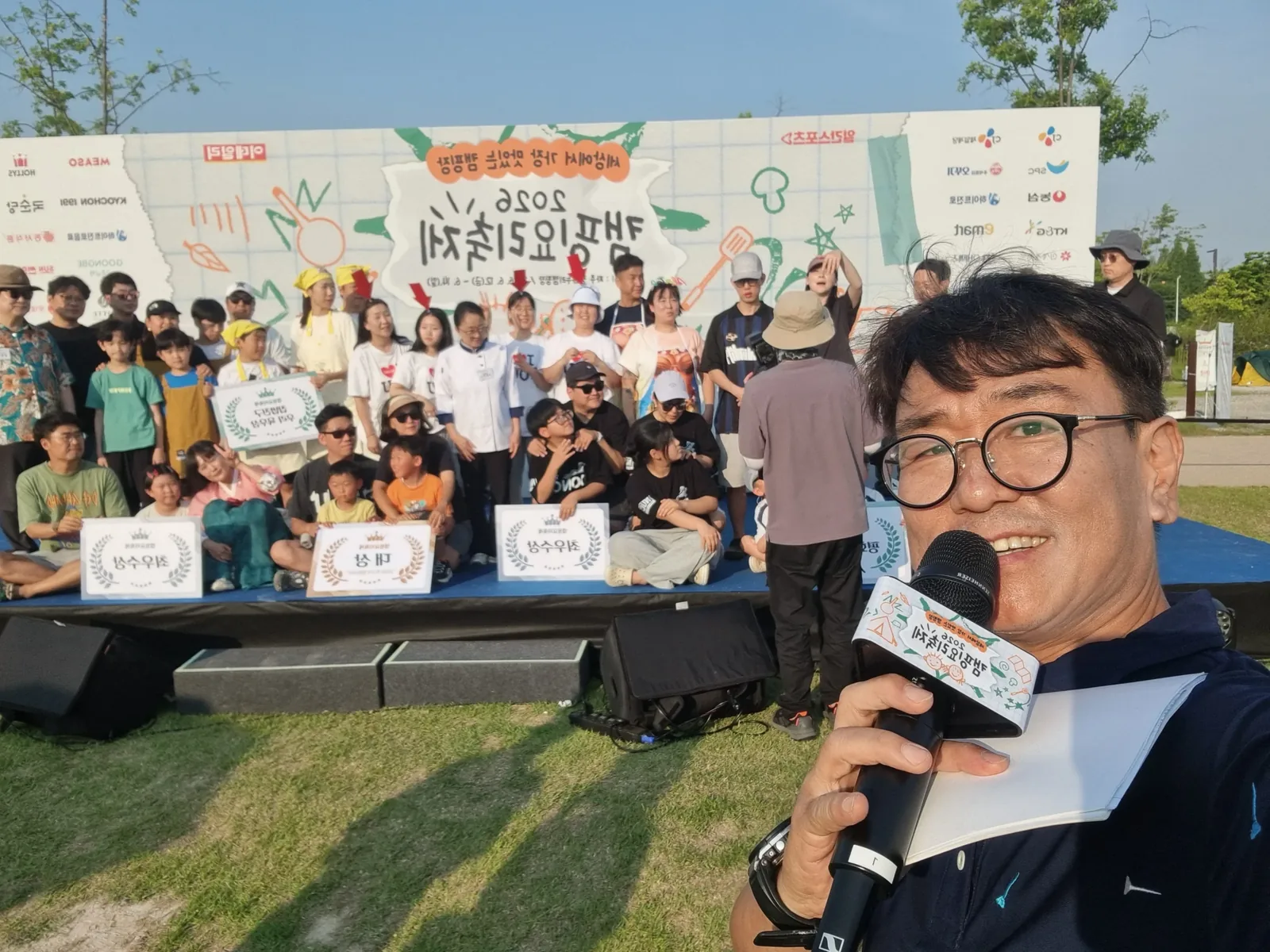 야외 워크숍 현장에서 마이크를 들고 안내하는 진행자