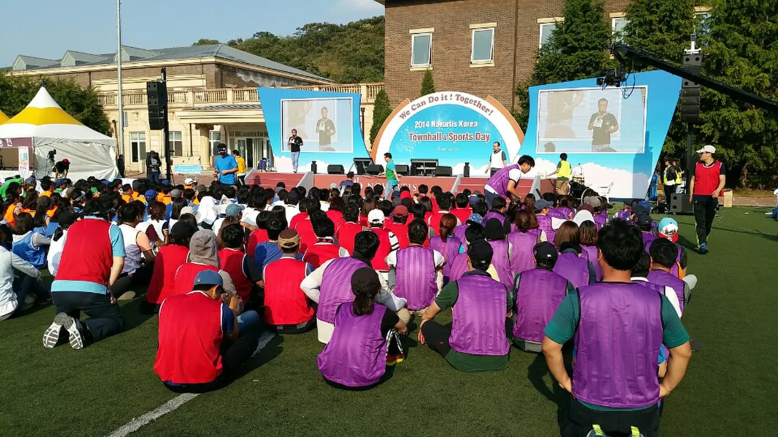 야외 워크숍에서 팀별 색상으로 나뉘어 앉은 참가자들