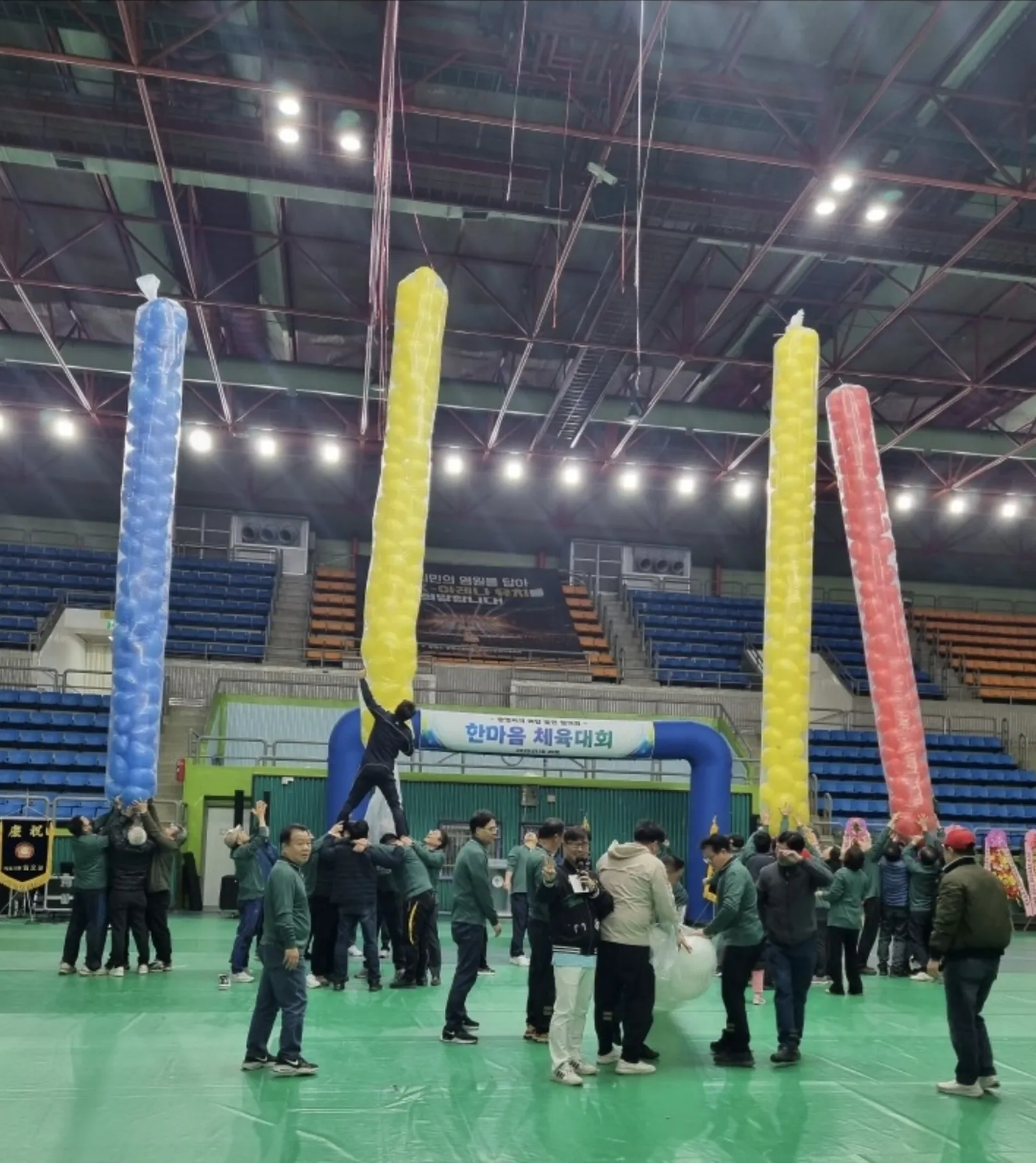 체육관에 설치된 대형 게임 장비와 모여 있는 참가자들
