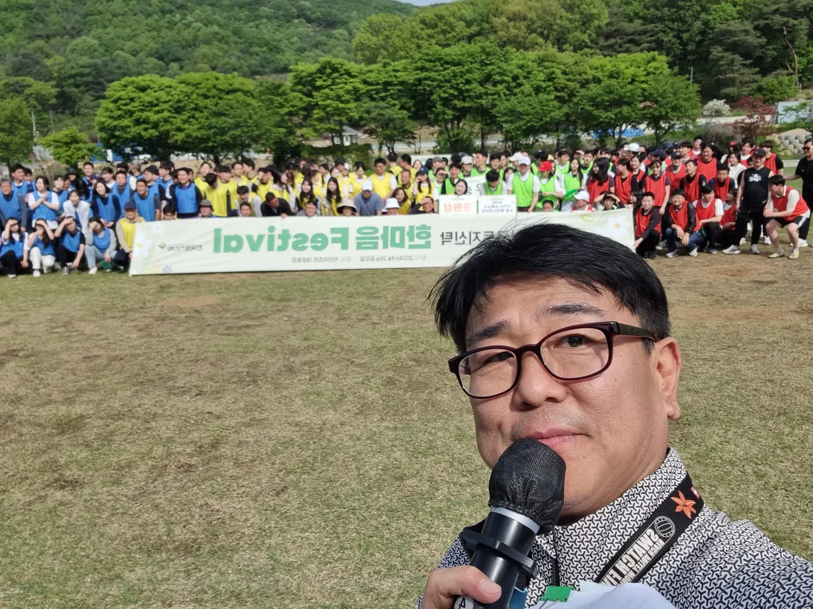 야외 워크숍 현장에서 마이크를 들고 진행하는 모습