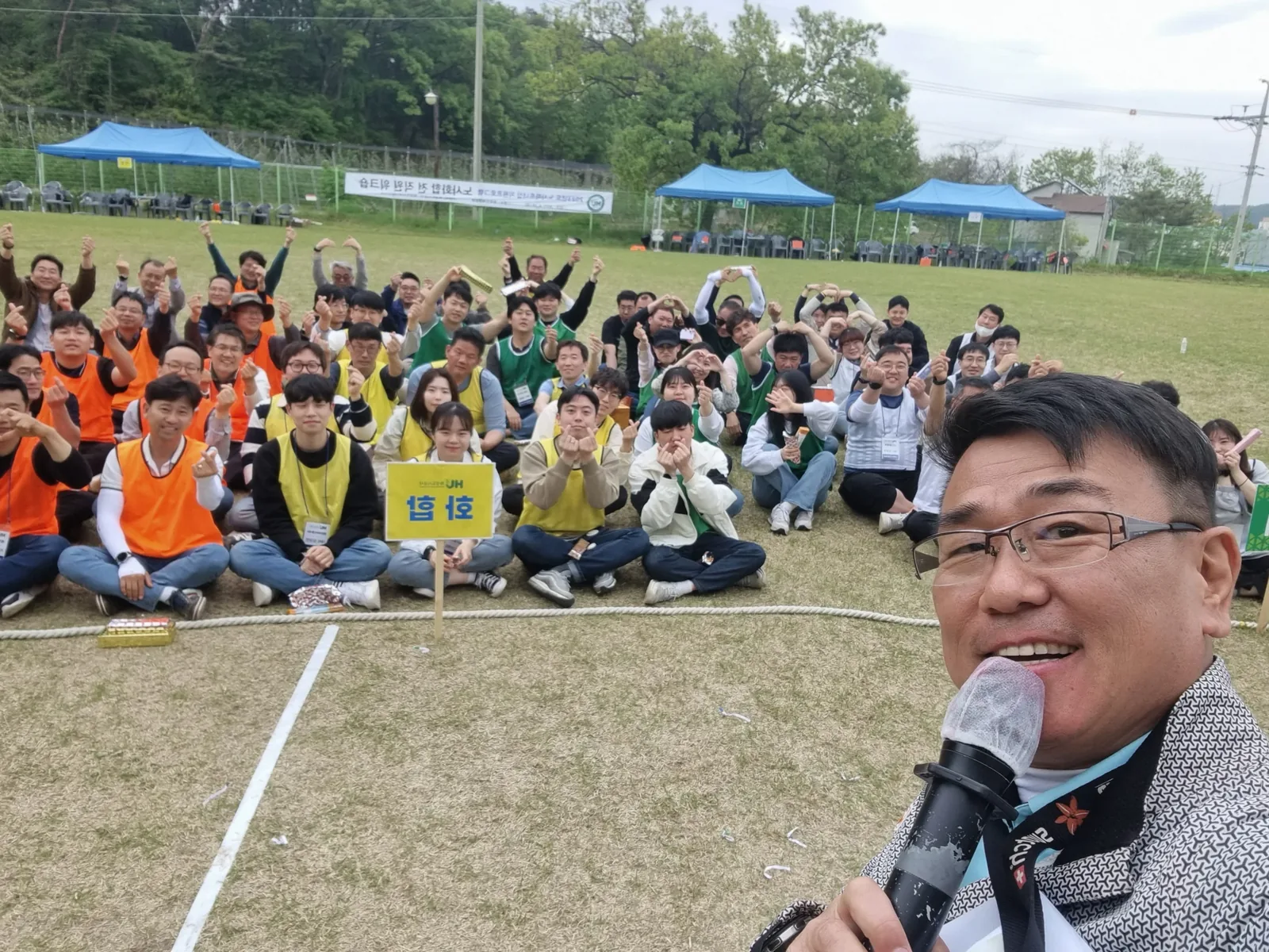 단체 참가자들 앞에서 마이크로 안내하는 진행자